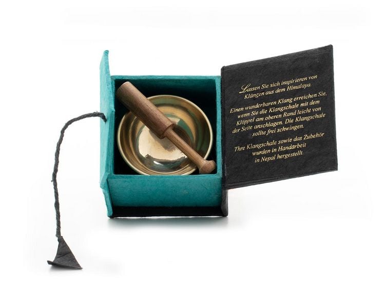 Produktbild: Mini-Klangschale mit zartem Klang f&uuml;r feines H&ouml;ren - die Geschenk Idee f&uuml;r kleine und gro&szlig;e Klangschalen Fans! Verpackt ist die gegossene Schale in einer Box aus handgesch&ouml;pftem Naturpapier mit raffinierter Knopfbindung. Inklusive Zubeh&ouml;r.