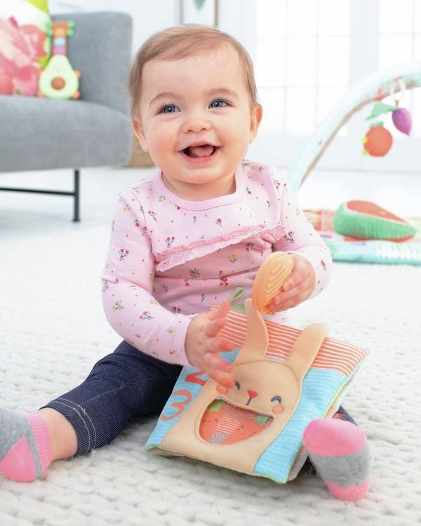 Produktbild: Das weiche Bauernhof Spielbuch bietet den Allerkleinsten eine ganze Menge zu entdecken: Es enth&auml;lt weiche Seiten mit Knitterger&auml;uschen, einen Babyspiegel, bunte Zahlen, Tiere und Gartenszenen. Die Karotte kann sowohl als Bei&szlig;ring als auch zum Spielen