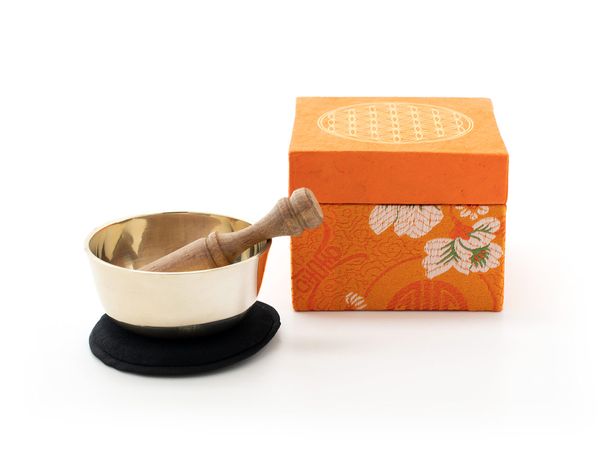 Produktbild: Kleine gegossene Klangschale mit einem hellen Klang und gravierter 'Blume des Lebens'. Verpackt ist die Schale in einer orangefarbenen Geschenk-Box aus handgesch&ouml;pftem Naturpapier mit 'Blume des Lebens' Aufdruck. Inklusive Kl&ouml;ppel und Stoffpad.